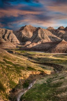 the mountains are brown and green in color as the sun goes down on them,