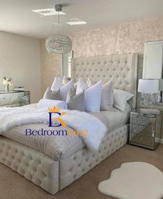 a large white bed sitting in a bedroom next to a dresser and mirror on the wall