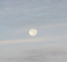 an airplane flying in the sky with a full moon behind it's back end