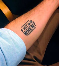 a man with a tattoo saying if not now, when? on his left arm