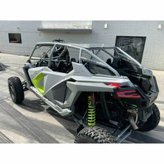 a grey and yellow dune buggy parked in front of a building