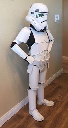 a star wars stormtrooper costume standing next to a wall