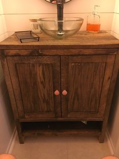 a bathroom sink with a wooden cabinet underneath it and a round mirror on the wall