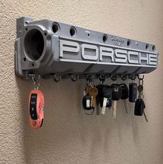 a car key holder with keys hanging from it's hooks and the word porsche on it