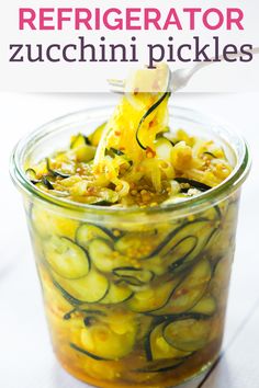 a jar filled with zucchini pickles sitting on top of a table