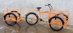 an orange bike parked next to a white wall