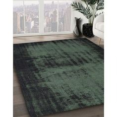 a green rug in front of a window with cityscape on the wall behind it