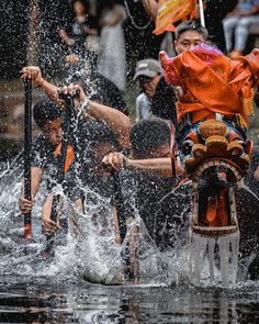 some people are riding on the back of a boat in water and splashing with their hands