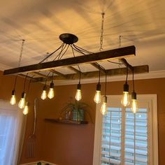 a light fixture hanging from the ceiling in a room with wooden beams and lights on it