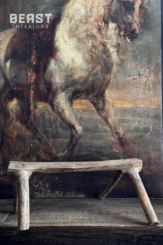 a wooden bench sitting in front of a painting on the side of a wall with a horse painted on it