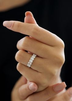 a woman's hand with a diamond ring on her finger, holding it in the air