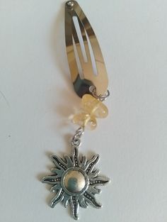 a fork with a sun charm hanging from it's side on a white surface