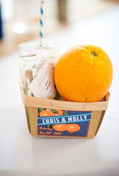 an orange sitting on top of a table next to a jar filled with toothpaste