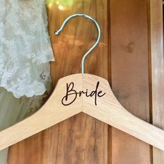 a wooden hanger with the word bride on it