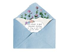 a blue envelope with flowers and a poem on the front that says, it's alright to be loved