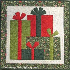 a quilted wall hanging with presents on it