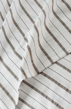 an image of a white and brown striped bedding set with gold lines on it