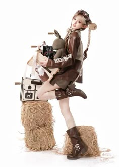 a woman dressed in costume sitting on top of hay bales holding a camera and cell phone