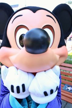 a person wearing a mickey mouse mask on top of a bench