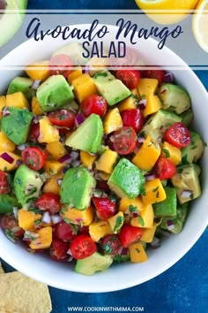 avocado mango salad in a white bowl with tortilla chips on the side