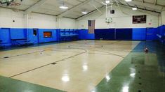 an indoor basketball court with blue and white walls