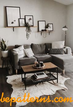 a living room with gray couches and pictures on the wall above them in black frames