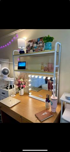 a desk with a laptop computer on top of it next to a shelf filled with other items