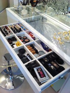 the drawers are filled with cosmetics and other items in front of a mirrored counter top