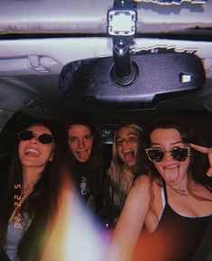 group of young women sitting in the back of a car