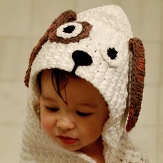 a small child wearing a crocheted dog hat