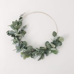 a wreath made out of green leaves and greenery