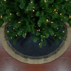 a christmas tree in a pot with lights on the top and around it's base