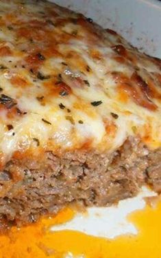 a large piece of meatloaf with cheese on top is in a casserole dish