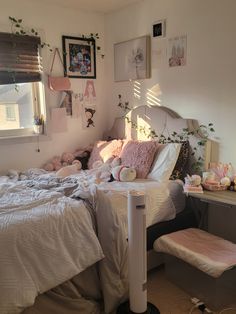 an unmade bed in a bedroom with pictures on the wall and other decorations around it