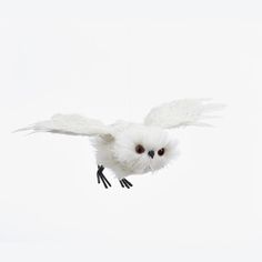 an owl flying through the air with its wings spread