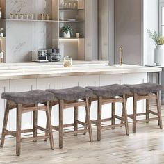 four stools are lined up in front of an island with marble countertops and shelves