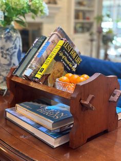 a wooden stand with books and oranges on it