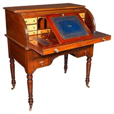 an old wooden desk with a blue book on it's top and two drawers