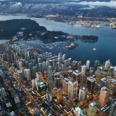 an aerial view of a city at night with the lights on and water in the foreground