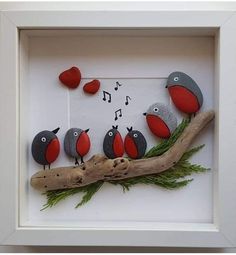 a group of birds sitting on top of a wooden branch in a white framed frame