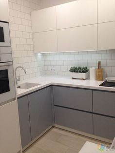 a kitchen with white and gray cabinets and counters