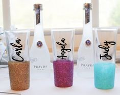 three empty wine bottles with glitter in them