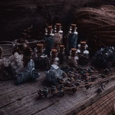 an assortment of bottles and rocks on a wooden table