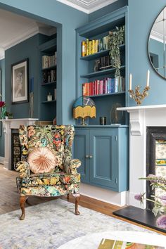 a living room filled with furniture and a fire place in front of a book shelf