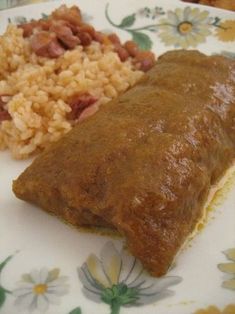 a close up of a plate of food with rice and beans on it, including meat