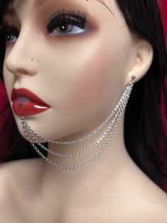 a mannequin with chains on it's neck and red lipstick in the background