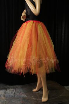 a mannequin dressed in an orange and yellow tulle skirt with black top