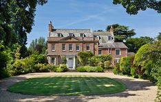 a large brick house surrounded by trees and bushes