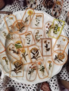 a white plate topped with lots of dried flowers on top of a lace covered table