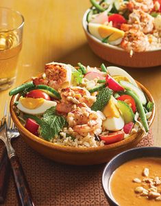 two bowls filled with food on top of a wooden table